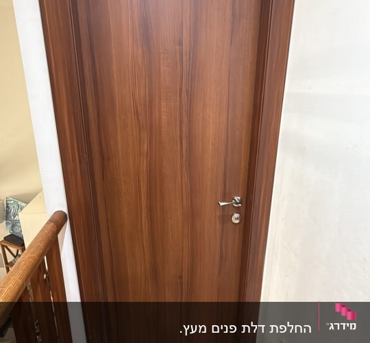 דלת פנים מותקנת בציפוי עץ חום עם משקוף תואם
